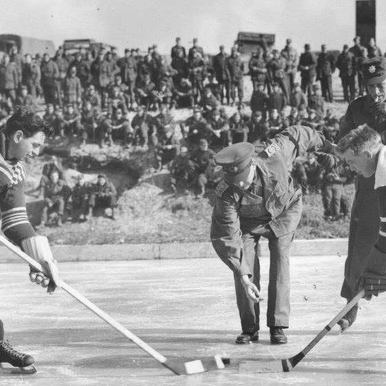 Two hockey players leaning over the waiting for the puck to drop.